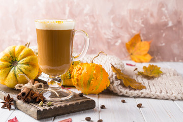 Cup of pumpkin spice latte with whipped cream on top and seasonal autumn spices, and fall decor. Traditional coffee drink for autumn or winter holidays, copy space.