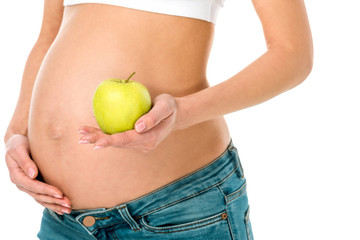 cheerful pregnant woman holding green apple isolated on white