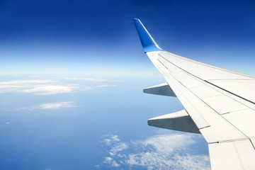 Tranquil view of blue sky with some clouds and sea under the wing of plane. Concept of peaceful....
