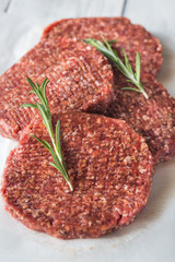Raw beef patties on the white parchment