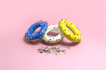 Humorous imitation of donuts from colored bagels with multi-colored pins