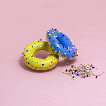 Humorous imitation of donuts from colored bagels with multi-colored pins
