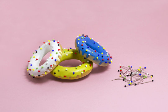 Humorous imitation of donuts from colored bagels with multi-colored pins
