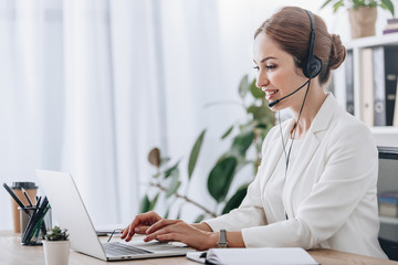 executive female operator working with headset and laptop in call center