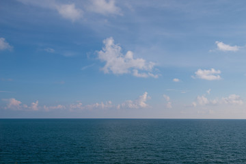 Naklejka na ściany i meble clouds blue sky above ocean and sea waves