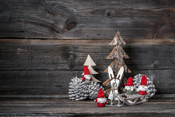 Weihnachtsdeko mit Weihnachtsmännern vor Holzhintergrund