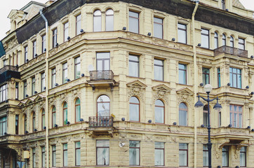 Fototapeta na wymiar Saint Petersburg, RUSSIA - July 08, 2018: Fragment of light brick facade building with windows. Saint Petersburg, Russia.