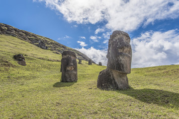 Vista frontale di una coppia di moai interrati sul vulcano spento Rano Raraku