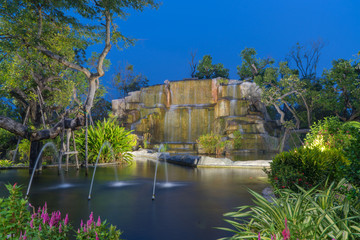 Fototapeta na wymiar Waterfall in garden at the public park in twilight time