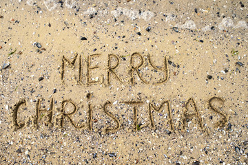 Merry Christmas written on tropical beach sand, copy space. Holiday concept, top view