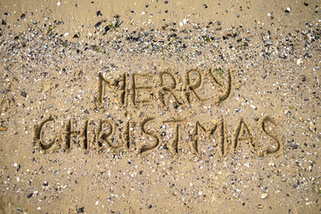 Fototapeta premium Merry Christmas written on tropical beach sand, copy space. Holiday concept
