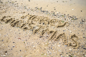 Merry Christmas written on tropical beach sand, copy space. Holiday concept