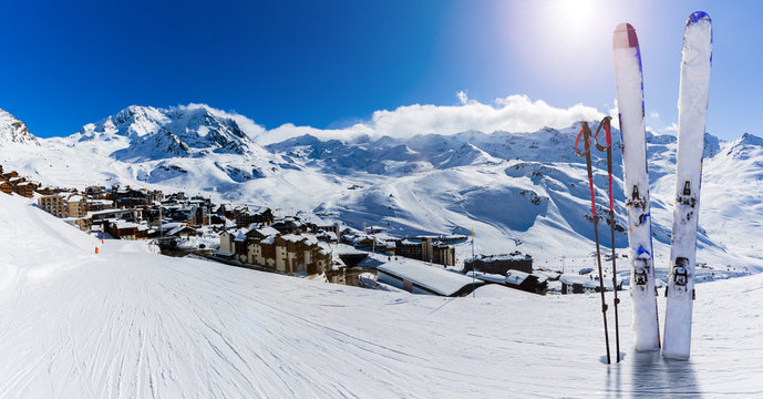 Ski in winter season, mountains and ski touring equipments on the top in sunny day in France, Alps above the clouds.