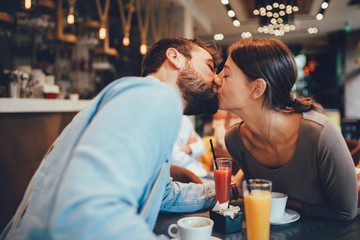 Young happy couple at a date in a coffee shop
