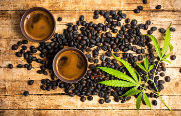 Cups of coffee with marijuana and roasted beans