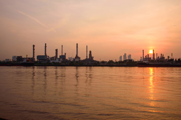 Fototapeta na wymiar Oil refinery at the river in sunrise time / Big Factory in sunrise time