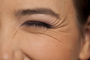 wink female eye with wrinkles around