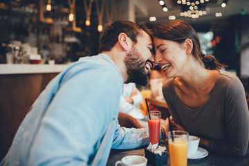 Young happy couple at a date in a coffee shop
