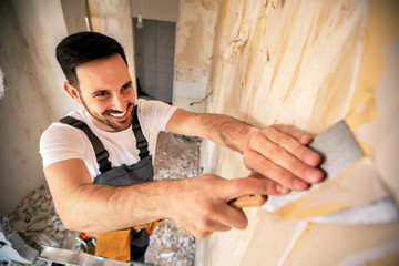 Scraping of wallpaper with a putty knife