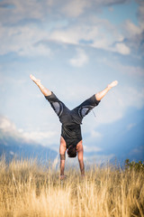 Ragazzo in verticale con panorama di montagna, a testa in giu