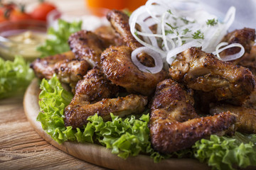 Grilled chicken wings  with onion and sauce.