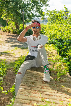 Extravagant (hipster) male model in nature. Model poses for a scarf, sunglasses and headphones.