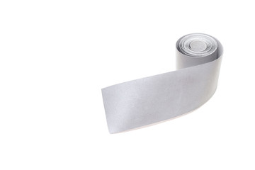 A roll of reflective tape on a white background, close-up, isolate, visibility, light reflection tape, equipment
