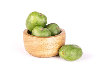 Lot of whole fresh green mini baby kiwi fruit one is near it with wooden bowl isolated on white background