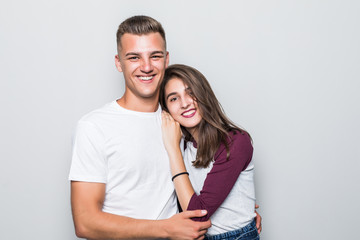 Portrait of happy couple looking at camera against gray background