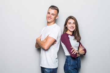 Fototapeta premium Portrait of an couple standing back to back and looking at camera over gray background