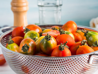 Italian tomatoes in a colander on table. Cooking with tomatoes concept. Local organic vegetables