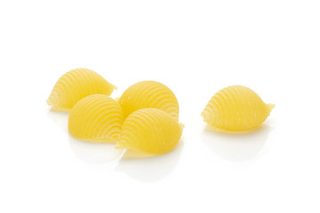 Set of five whole raw yellow pasta conchiglie variety isolated on white background