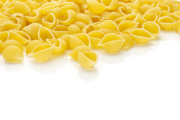 Lot of whole italian raw yellow pasta conchiglie variety isolated on white background