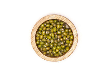 Lot of whole dry green mung beans with wooden bowl flatlay isolated on white background