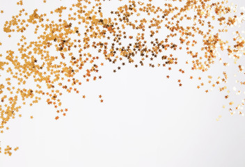 Golden glitter decor on the white background with copy space,