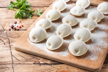 Raw dumplings on a wooden chopping Board in the kitchen