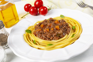 Pasta with bolognese sauce. In a white plate. The background is white. Italian food.