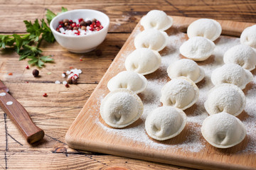 Raw dumplings on a wooden chopping Board in the kitchen