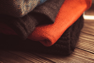 folded woolen things on wooden background insulate, vintage image selective focus