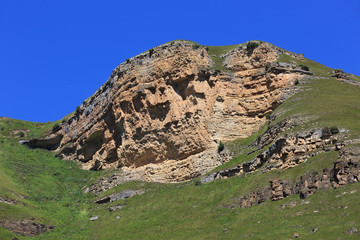 Stone ledge of a rocky ridge against the blue sky.