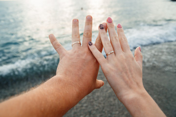 hands newlyweds on the background of the sea, honeymoon