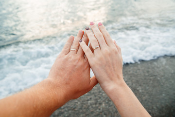 hands newlyweds on the background of the sea, honeymoon