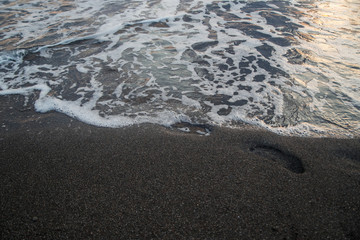 Footprints on the sea sand at sunset
