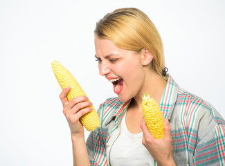 Girl practice eating only or mostly food uncooked and unprocessed. Woman farmer choose yellow corn cob on white background. Girl rustic style hold ripe corn. Make healthy choice. Vegetarian product