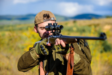 Hunting target. Looking at target through sniper scope. Man hunter aiming rifle nature background. Hunting skills and weapon equipment. Guy hunting nature environment. Hunting weapon gun or rifle
