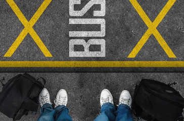  men with a shoes and backpacks are standing next to Bus stop