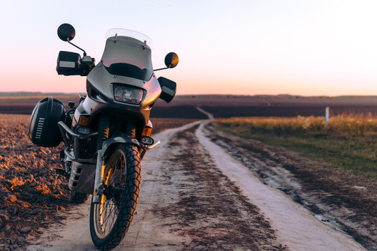 adventure old timer motorcycle for tourism stand alone, autumn sunset, motorcycle off road, adventurer, extreme vacation, cold weather clothes, copy space