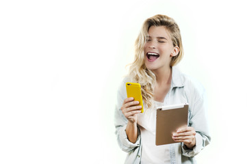 Young very beautiful business girl with a phone and ipad in her hands smiles and laughs at what she saw in on a white background