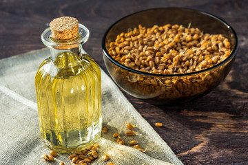 Sprouted wheat and wheat germ oil on wooden background.