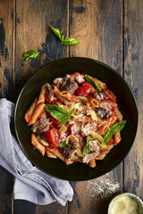 Wholegrain penne pasta with tomato and tuna in red sauce.Top view.